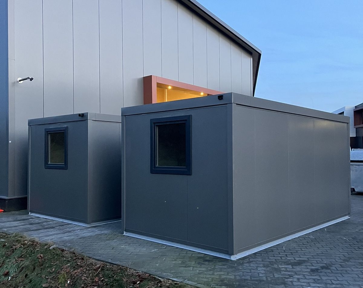 Groby van naast beige prefab bedrijfsberging op locatie