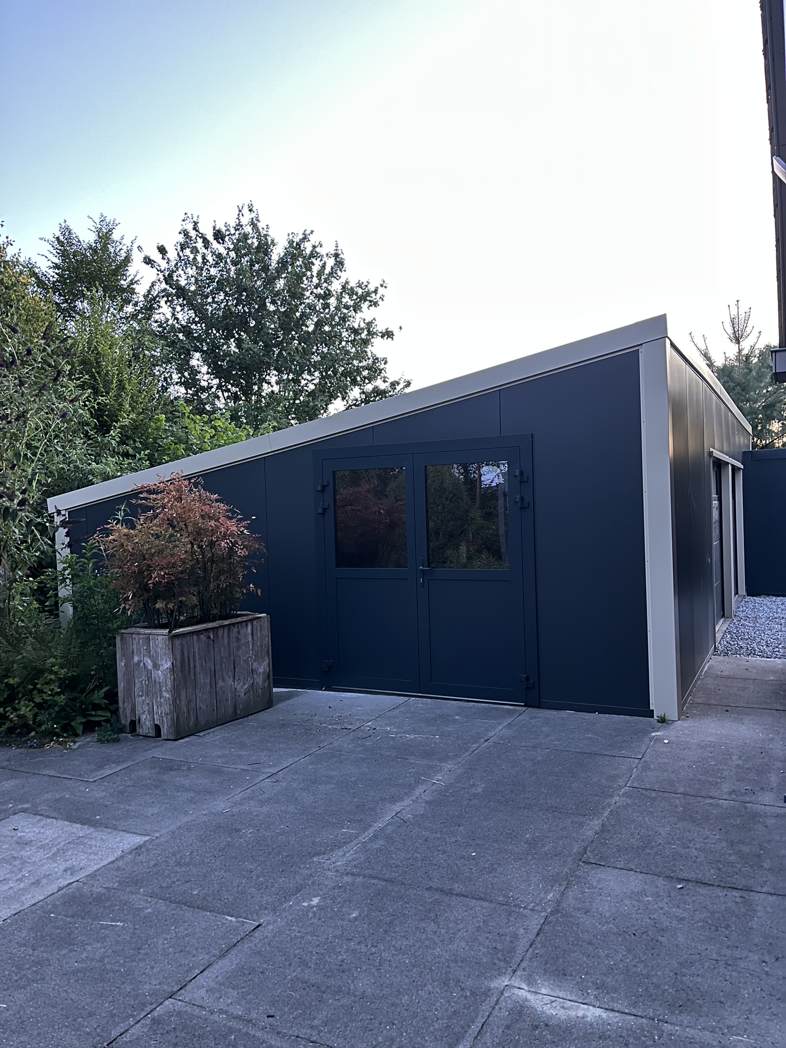 Groby schuur garage Elspeet donkere gevel dubbele deur en beige dakrand
